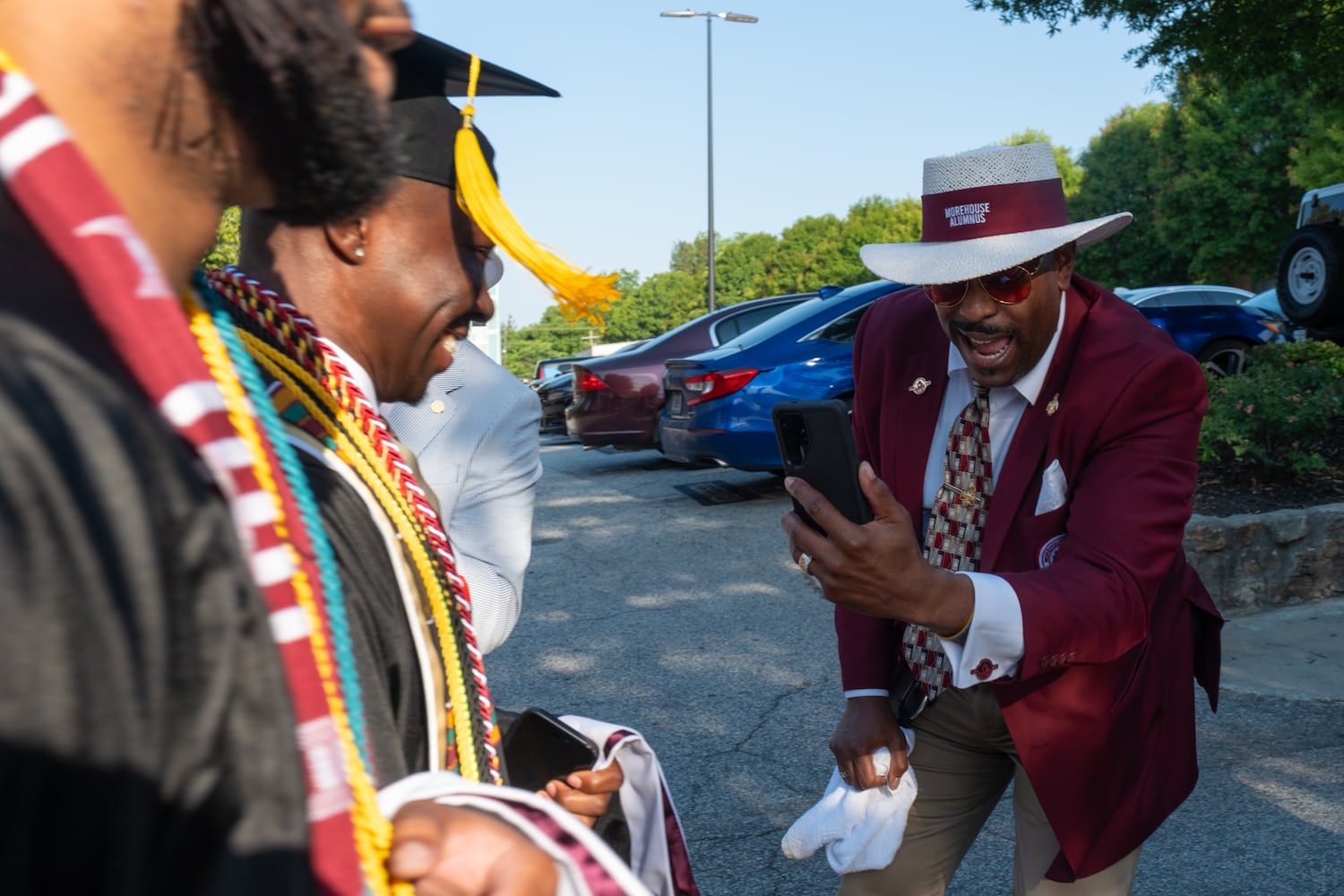 John Radford, Morehouse College class of 1996, cheers on students as they make their way down the alumni corridor on the way to commencement Sunday, May 17, 2026. (Ben Gray for the AJC)