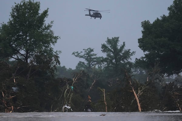A helicopter flies over the Guadalupe River after a flash flood swept through the area, Friday, July 4, 2025, in Kerrville, Texas. (AP Photo/Eric Gay)