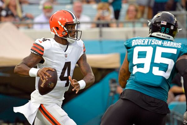 Cleveland Browns quarterback Deshaun Watson (4) looks for a receiver as he is pressured by Jacksonville Jaguars defensive end Roy Robertson-Harris (95) during the first half of an NFL preseason football game, Friday, Aug. 12, 2022, in Jacksonville, Fla. (AP Photo/Phelan M. Ebenhack)