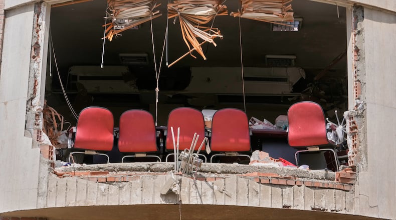 A row of chairs is seen through a hole left by U.S.-Israeli airstrikes Friday at Shahid Beheshti University in Tehran, Iran, Saturday, April 4, 2026. (AP Photo/Vahid Salemi)