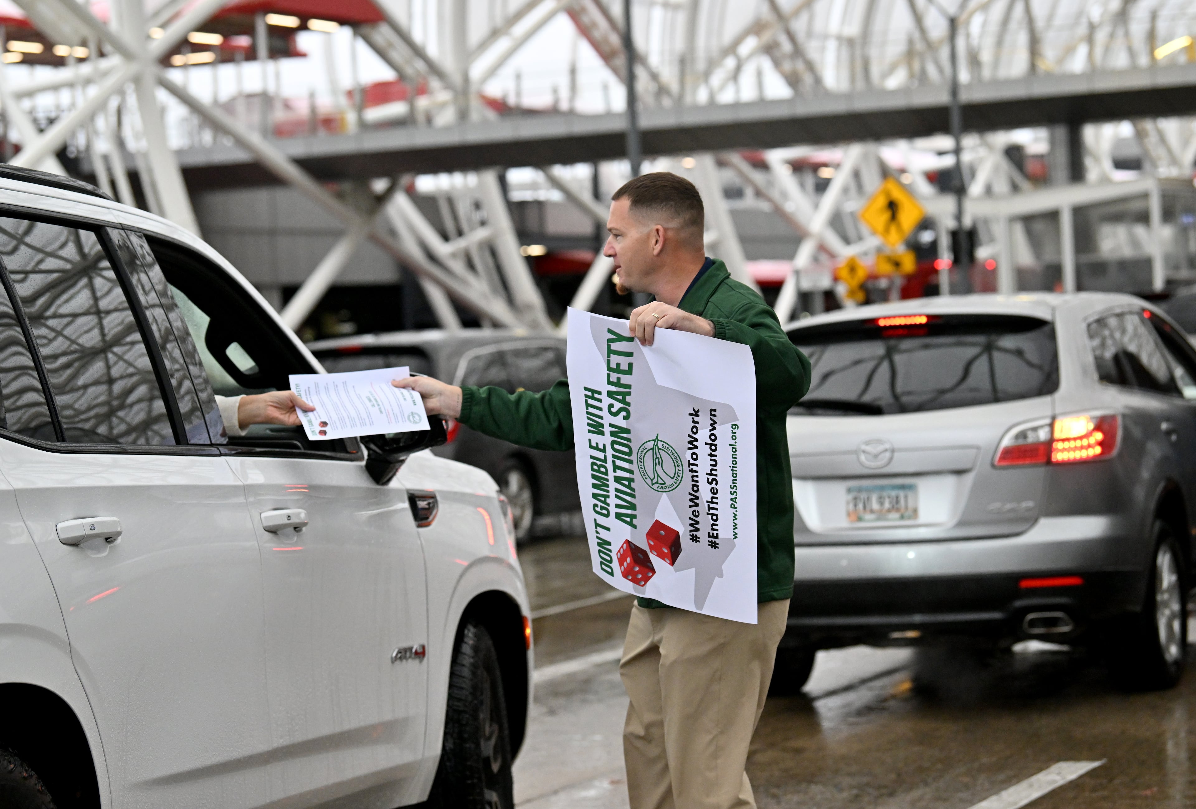 Doug Lowe, regional vice president of PASS, hands out flyers to airport travelers at Hartsfield-Jackson Atlanta International Airport's domestic terminal, Wednesday, October 29, 2025, in Atlanta. (Hyosub Shin/AJC)