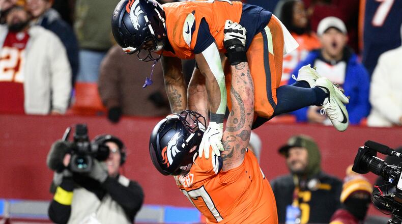Denver Broncos running back RJ Harvey, is lifted by teammate Quinn Meinerz after scoring during overtime of an NFL football game against the Washington Commanders Sunday, Nov. 30, 2025, in Landover, Md. (AP Photo/Nick Wass)