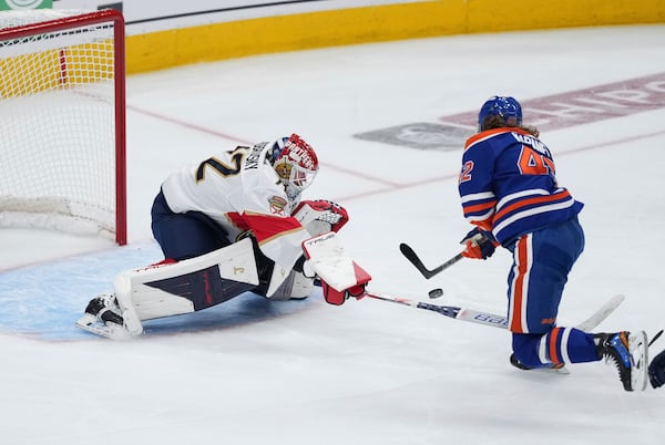 Edmonton Oilers' Kasperi Kapanen, right, puts a shot wide of the net as Florida Panthers goalie Sergei Bobrovsky poke-checks him during the first overtime period in Game 1 of the NHL Stanley Cup Final, in Edmonton, Alberta, on Wednesday, June 4, 2025. (Darryl Dyck/The Canadian Press via AP)