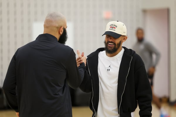 Hawks guard Trae Young (right) greets general manager Onsi Saleh before draft pick Asa Newell's introductory news conference.