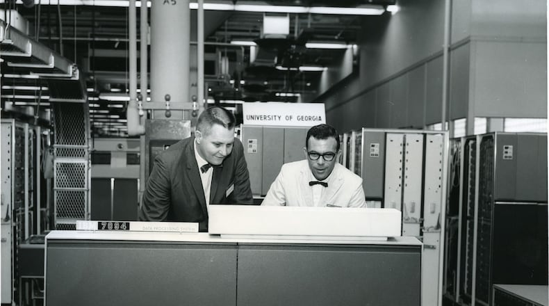 James L. Carmon (left) stands surrounded by an IBM 7094, which, in 1964, was the state-of-the-art supercomputer. Carmon helped acquire a 7094 for the University of Georgia, which eventually put UGA in the service of the Apollo program. CONTRIBUTED BY UNIVERSITY OF GEORGIA