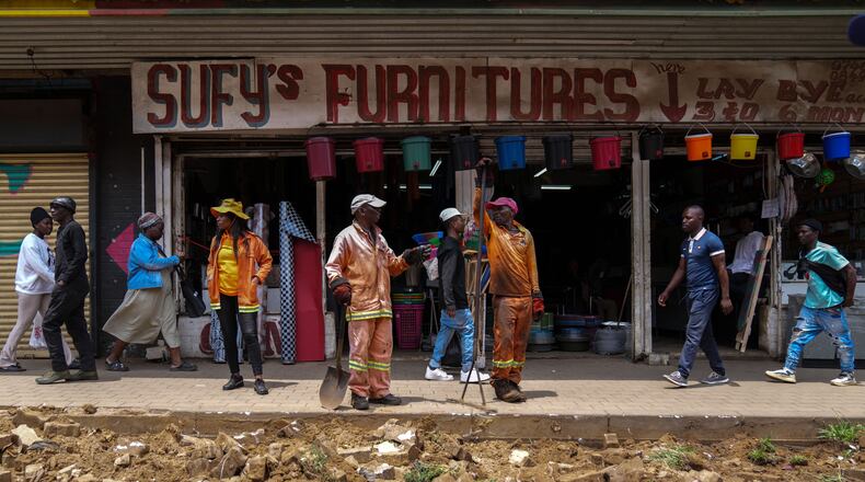 Workers fix a road in Johannesburg's Soweto township as a massive cleanup job gets underway in anticipation of the upcoming G20 summit to be held in the South African economic capital, Friday, Nov. 14, 2025. (AP Photo/Jerome Delay)