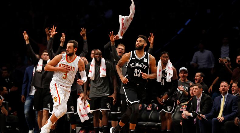 Brooklyn Nets' Allen Crabbe (33) reacts along with his bench after making a three-point basket in front of Atlanta Hawks' Marco Belinelli (3) during the fourth quarter of an NBA basketball game Sunday, Oct. 22, 2017, in New York. (AP Photo/Adam Hunger)