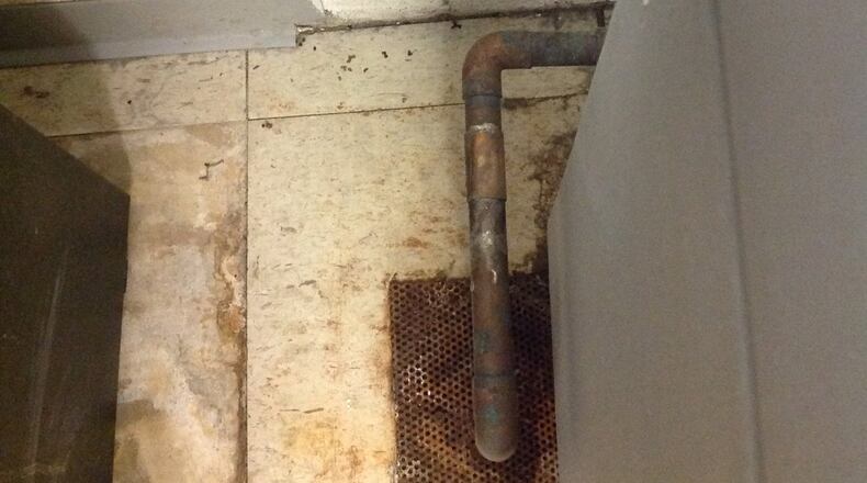 A rusted drain at Augusta State Medical Prison. Hanging down is a black piece of rubber used to divert rainwater when the roof leaks.