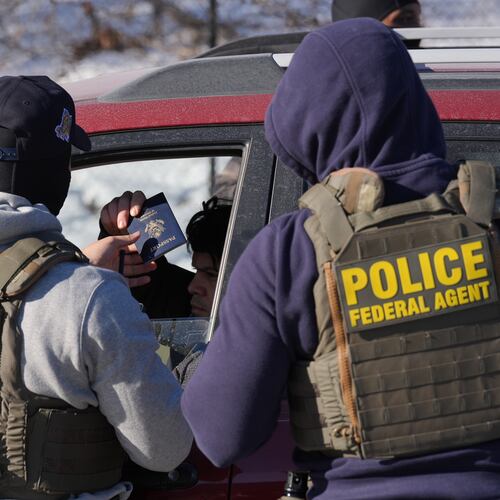 Federal agents make a traffic stop on a U.S. citizen as they provide their identification including a passport and drivers license, Tuesday, Jan. 27, 2026, in Minneapolis. (AP Photo/Adam Gray)