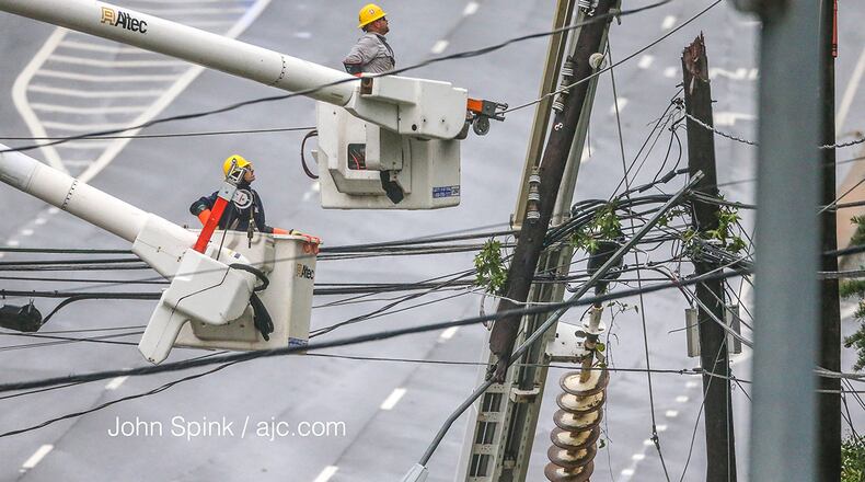 Workers continue to try to restore power along Hammond Drive in Sandy Springs on the morning of Tuesday, Sept. 12, 2017. More than 1.2 million Georgians remained without power the morning after Tropical Storm Irma passed through the state. (John Spink / jspink@ajc.com)
