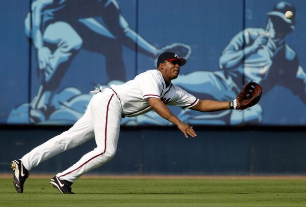 Braves center fielder Andruw Jones makes a diving catch against Pittsburgh shortstop Jack Wilson on Friday, Sept. 5, 2003, at Turner Field in Atlanta. (Brant Sanderlin/AJC)