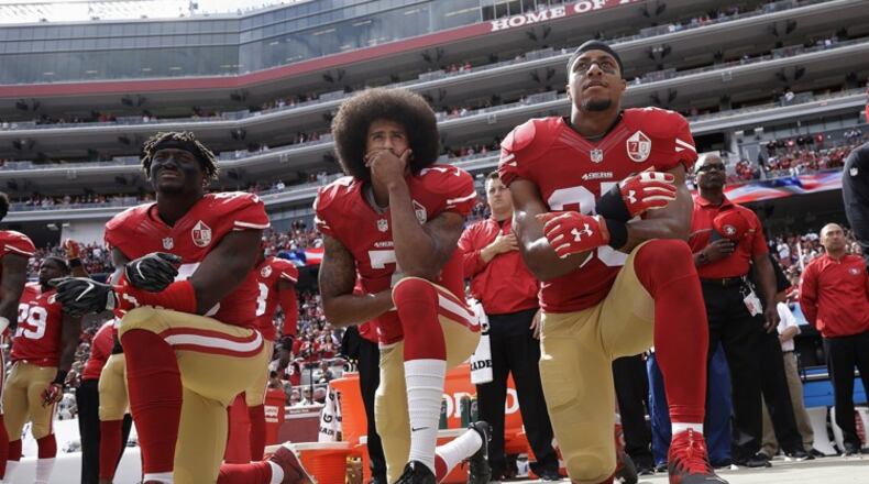 2016 AP YEAR END PHOTOS - San Francisco 49ers outside linebacker Eli Harold, left, quarterback Colin Kaepernick, center, and safety Eric Reid kneel during the national anthem before an NFL football game against the Dallas Cowboys in Santa Clara, Calif., on Oct. 2, 2016. (AP Photo/Marcio Jose Sanchez, File)