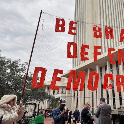 Protestors opposed to mid-decade redistricting hold a sign outside of the Florida Capitol in Tallahassee, Fla. on Dec. 4, 2025. (AP Photo/Kate Payne)