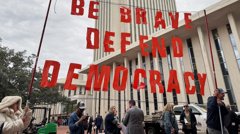 Protestors opposed to mid-decade redistricting hold a sign outside of the Florida Capitol in Tallahassee, Fla. on Dec. 4, 2025. (AP Photo/Kate Payne)