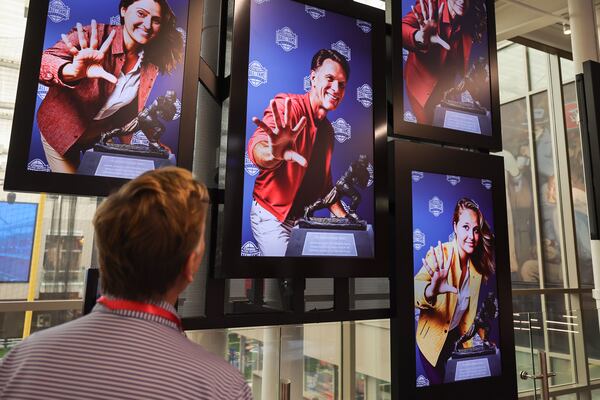 Jeff Wansley looks at his face at The Champions & Contenders exhibit that is part of new GAME ON! AI Experience at The College Football Hall of Fame in Atlanta on Friday, Aug. 23, 2024. GAME ON! uses generative AI to collect information to gives guests a customized fan experience throughout the exhibits. (Natrice Miller/ AJC)