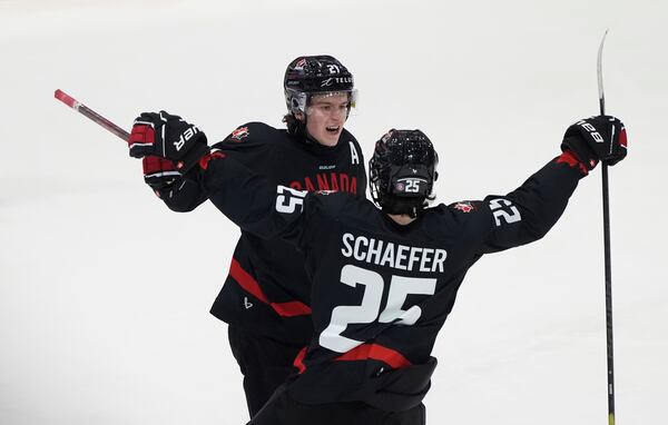 FILE - Canada forward Calum Ritchie, left, celebrates after his goal with defenseman Matthew Schaefer during third-period IIHF World Junior Hockey Championship pretournament action, Dec. 21, 2024, in Ottawa, Ontario. (Adrian Wyld/The Canadian Press via AP, file)