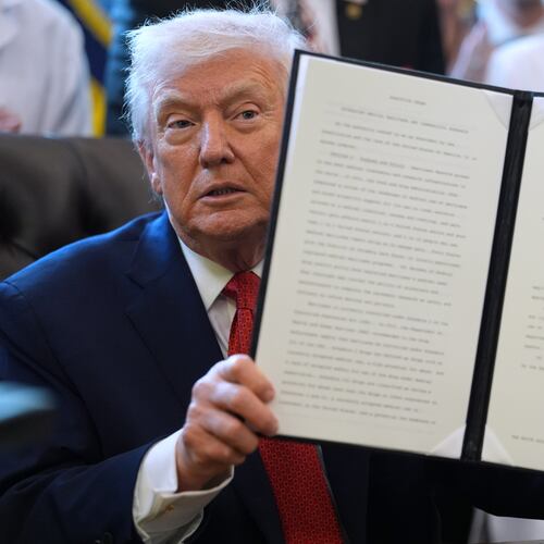 President Donald Trump displays an executive order reclassifying marijuana as a less dangerous drug in the Oval Office of the White House, Thursday, Dec. 18, 2025, in Washington. (AP Photo/Evan Vucci)