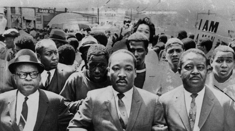 The late Bishop B. Julian Smith of the Episcopal District of the Christian Methodist Church, left, and Rev. Ralph Abernathy, right, flank Dr. Martin Luther King, Jr., during a civil rights march in Memphis, Tenn., March 28, 1968. (AP Photo/Jack Thornell)