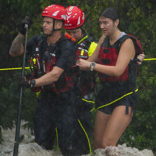 Members of the Boerne Fire Dept. rescue a woman from flood waters on Wednesday, July 15, 2026, in Boerne, Texas. (AP Photo/Darren Abate)