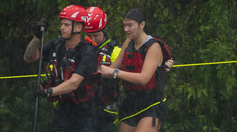 Members of the Boerne Fire Dept. rescue a woman from flood waters on Wednesday, July 15, 2026, in Boerne, Texas. (AP Photo/Darren Abate)