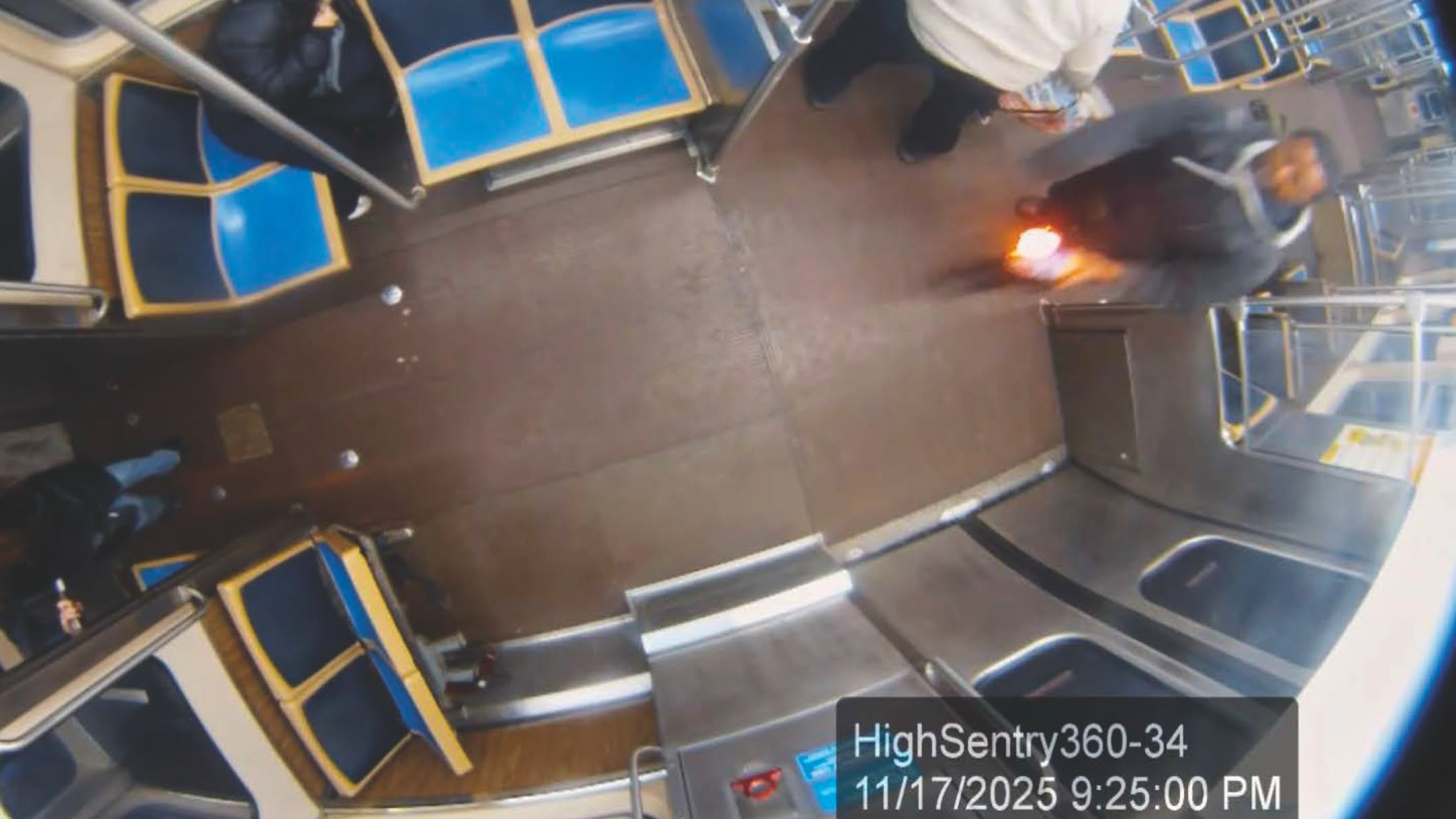 This still image taken from Chicago Transit Authority surveillance footage and included in a federal court record shows a man who federal authorities identified as Lawrence Reed holding a flaming bottle and approaching a passenger, far left, on Monday, Nov. 17, 2025, on a Chicago Blue Line train. (Chicago Transit Authority/U.S. District Court Northern District of Illinois via AP)