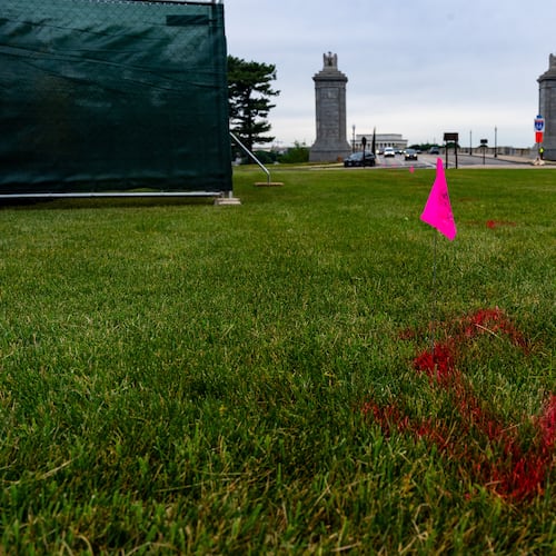 FILE - Flags are placed as workers survey the Memorial Circle, where President Donald Trump has proposed building an arch to commemorate the United States' 250th anniversary, May 11, 2026, in Washington. (AP Photo/Alex Brandon, File)