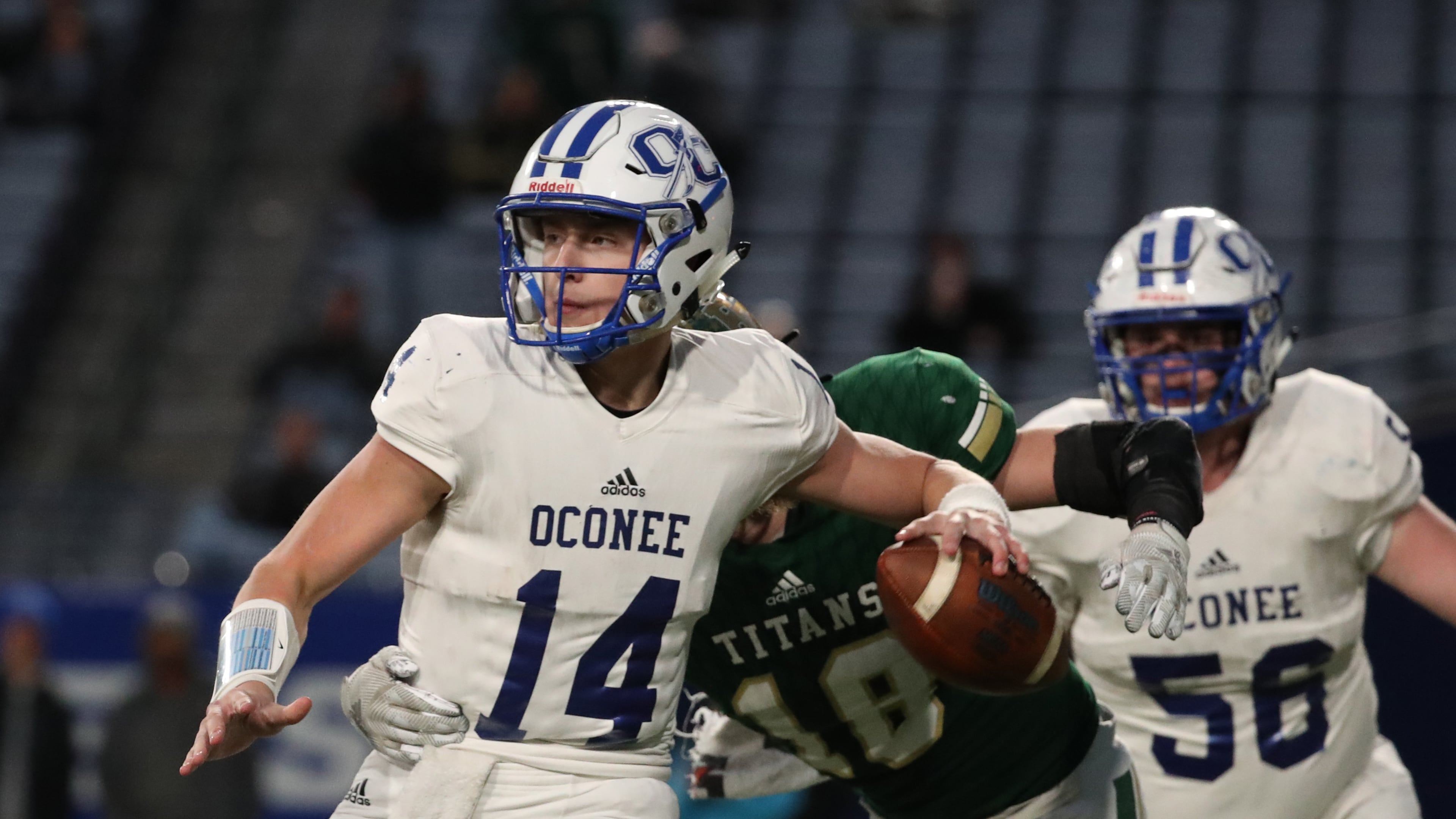 Oconee County quarterback Max Johnson (left) attempts a pass against the pressure from Blessed Trinity linebacker Michael Mitchler in the first half of the Class AAAA high school football state title at Georgia State Stadium in Atlanta. (Jason Getz/AJC 2019)