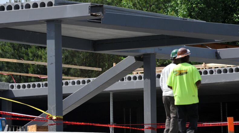 Two workers were injured when a beam they were working on collapsed, sending them crashing 15-20 feet to the ground on May 15, 2014, in Sandy Springs. The men were working on a parking garage for a new hotel under construction on Crestline Drive when they were injured. The workers were transported to Grady Hospital. KENT D. JOHNSON/KDJOHNSON@AJC.COM