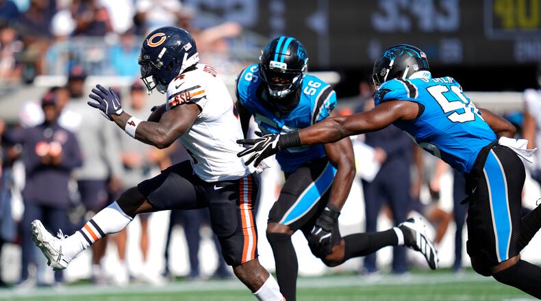 Chicago Bears running back D'Andre Swift (4) runs against Carolina Panthers linebacker Jeremiah Moon (56) and inside linebacker Bobby Okereke (58) to score a touchdown during the second half of an NFL football game, Sunday, Sept. 13, 2026, in Charlotte, N.C. (AP Photo/Erik Verduzco)