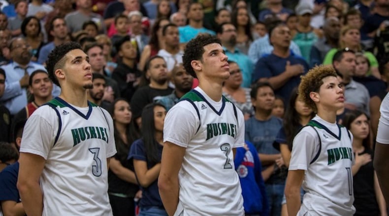 The sibling stars of Chino Hills High, from left: LiAngelo, Lonzo and LaMelo Ball, before a home game in Chino Hills, Calif., Feb. 10, 2016. Playing a full-time, full-court press and averaging almost 100 points a game, the 27-0 Huskies are the top-ranked team in the nation, and all three Ball brothers have committed to play at UCLA. (Monica Almeida/The New York Times)