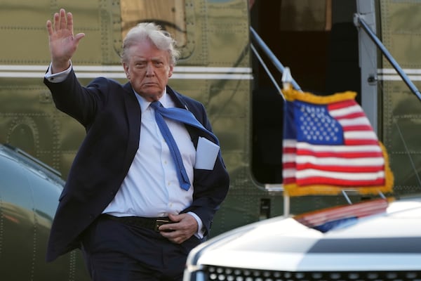President Donald Trump waves while heading to the Trump National Golf Club in Sterling, Va.