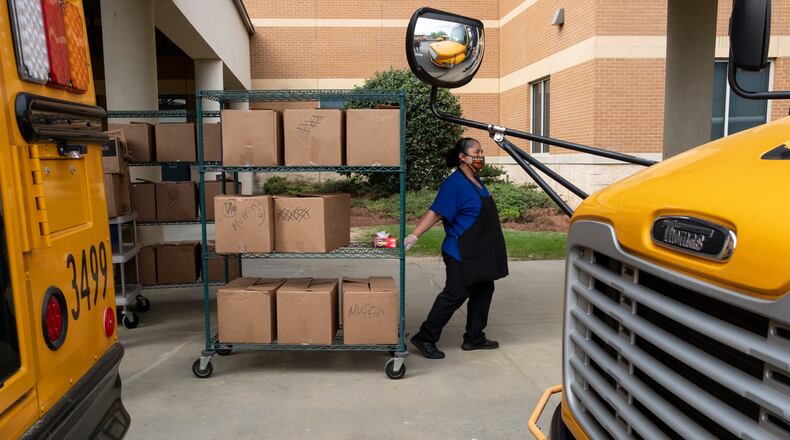 Gwinnett County cafeteria workers bring freshly prepared food out to waiting school buses in front of Berkmar High School so they can be delivered to students around the district in April. Ben@BenGray.com for the Atlanta Journal-Constitution