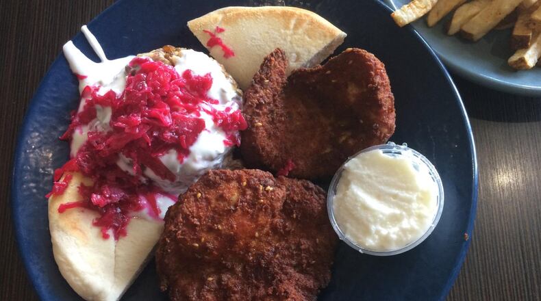 The chicken schnitzel with pita, garlic mayo and mejadara (lentil stew topped with yogurt and pickled red cabbage) at Cafe Raik. CONTRIBUTED BY WENDELL BROCK