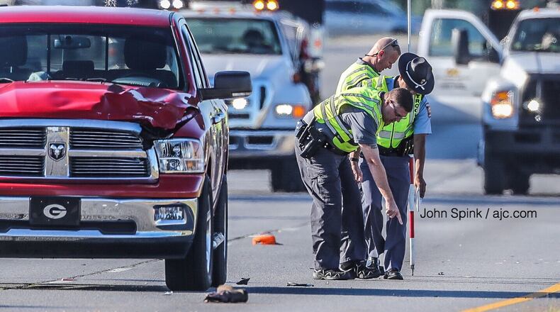 Georgia State Patrol troopers investigate after a police said an asphalt worker was hit by a red Dodge pickup truck and killed on Tara Boulevard on Tuesday morning.