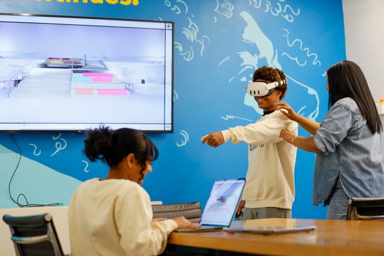Shana Sanders, founder and CEO of We Create Tech, works with King Arrington as Natasha Narine navigates a 3D space during a VR program class at Polywood. Sanders and her team have led immersive experiences in coding and AI, and are now pioneering a culturally responsive VR education space. (Miguel Martinez/AJC 2025)