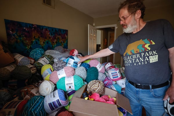 Penn Collins sorts through the pile of yarn on his bed at his home in Johns Creek. (Natrice Miller/AJC)
