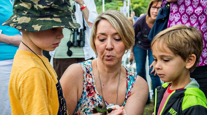 August 29, 2015 Kennesaw - Hugh Granden (left) helps release a hummingbird back into the wild with the help of Julia Elliott as Ricardo Irizarry watches during the Hummingbird Banding Festival at the Smith Gilbert Gardens in Kennesaw on Saturday, August 29, 2015. The fifth annual event helps identify hummingbirds as they migrate to Mexico while providing fun and education for people attending the event. JONATHAN PHILLIPS / SPECIAL