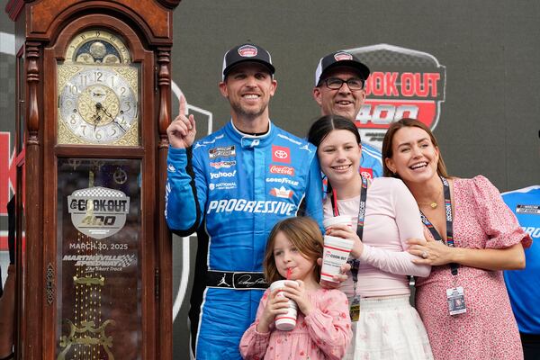 Denny Hamlin poses with the trophy in Victory Lane after winning a NASCAR Cup Series auto race in Martinsville, Va., Sunday, March 30, 2025. (AP Photo/Chuck Burton)