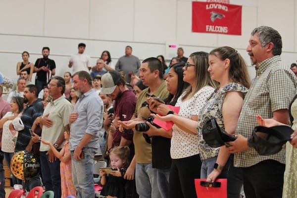 Family and friends recite the New Mexico state flag pledge ahead of a kindergartens' graduation ceremony at the elementary school in Loving, N.M., on Tuesday, May 20, 2025. (AP Photo/Susan Montoya Bryan)