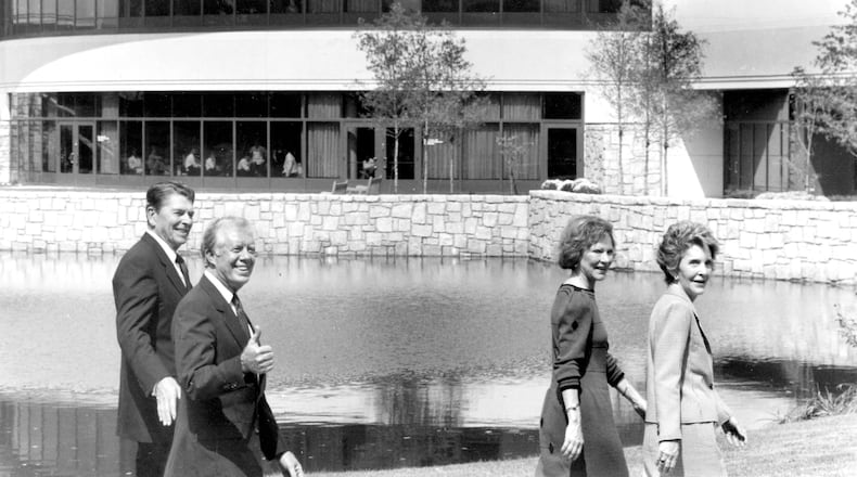 Jimmy Carter gives a thumbs-up sign as he and Rosalynn give a tour of the Carter Center to Ronald and Nancy Reagan.