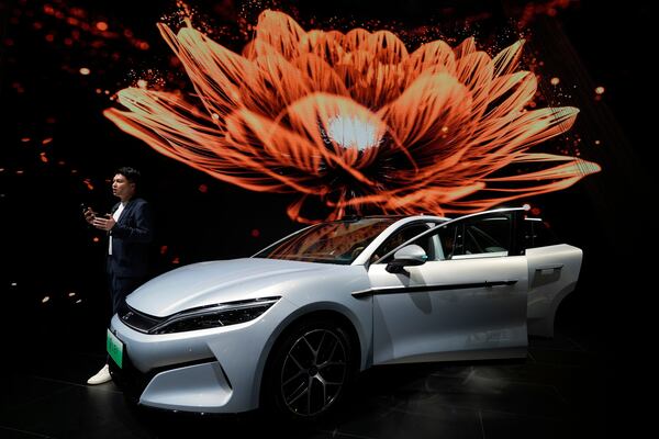 A man talks near the Han L EV model from BYD during the Shanghai auto show on Wednesday, April 23, 2025. (AP Photo/Ng Han Guan)