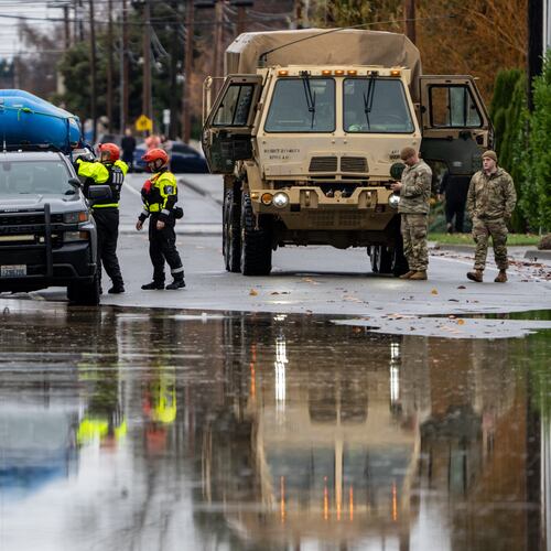 Emergency crews, including National Guard soldiers, wort in a neighborhood flooded by the Skagit River on Friday, Dec. 12, 2025, in Burlington, Wash. (AP Photo/Stephen Brashear)