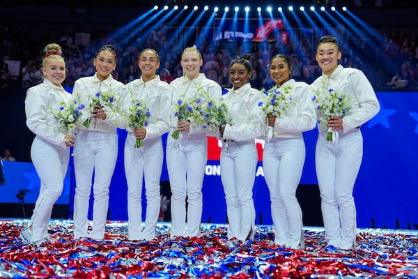 Joscelyn Roberson (left), Suni Lee, Hezly Rivera, Jade Carey, Simone Biles, Jordan Chiles and Leanne Wong (right) smile after they were named to the 2024 Olympic team at the United States Gymnastics Olympic Trials on Sunday, June 30, 2024, in Minneapolis. (Charlie Riedel/AP)