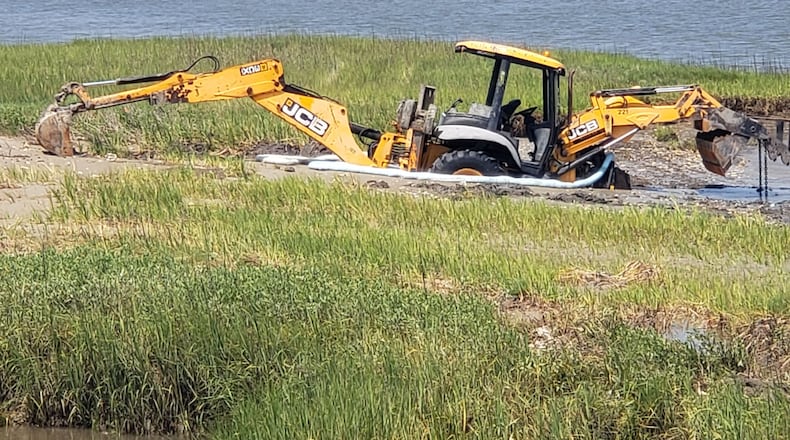 Two backhoes and a pickup truck became stuck while trying to remove a sunken Tybee Island police ATV. The ATV and one of the backhoes have been removed, and work is scheduled to begin Thursday to lift the remaining vehicles out of the mud using a crane and a barge.