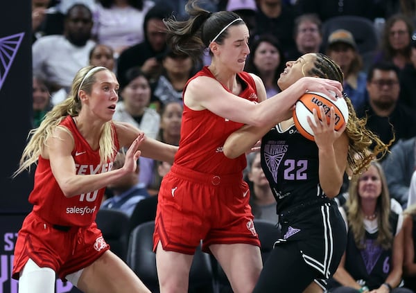 Golden State Valkyries' Veronica Burton (22) is fouled by Indiana Fever's Caitlin Clark, center, as Fever's Lexie Hall, left, looks on in thee second quarter of a WNBA game in San Francisco, Thursday, June 19, 2025. (Scott Strazzante/San Francisco Chronicle via AP)