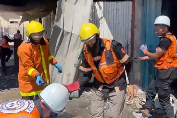 In this frame grab from a video released by Gaza Civil Defense, workers collect human remains after an Israeli strike on a home in Khan Younis killed nine of a doctor's ten children while she was at work, according to Ahmad al-Farra, head of the pediatric department at Nasser Hospital, in Khan Younis, Gaza Strip, Saturday, May 24, 2025. (Gaza Civil Defense via AP)