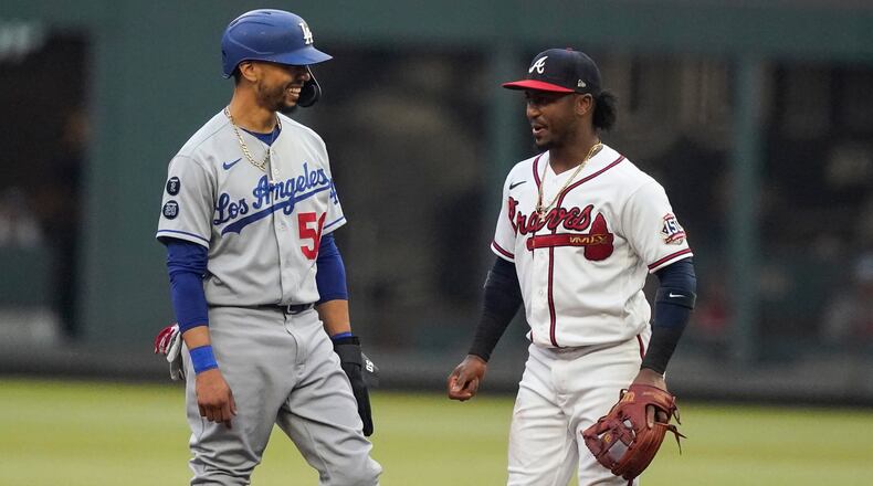 Los Angeles Dodgers' Mookie Betts, left, laughs with Atlanta Braves second baseman Ozzie Albies, right, in the first inning of a baseball game Saturday, June 5, 2021, in Atlanta. (AP Photo/Brynn Anderson)