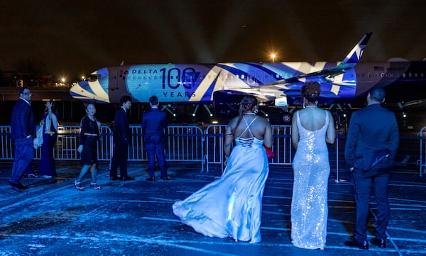 Delta Air Lines celebrates its 100-year anniversary on Saturday, March 15, 2025, at the Delta Flight Museum. More than 1,200 people were expected to attend. After formal remarks, the crowd went outside for the unveiling of a new plane livery, and a lights show projected onto the plane. (Jenni Girtman for The Atlanta Journal-Constitution)
