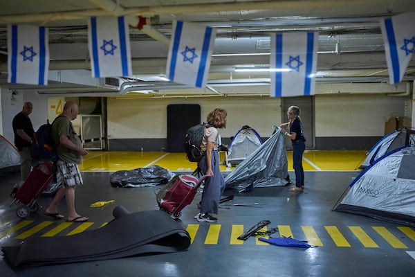 People fold tents at an underground shelter they stayed in during the war with Iran after the ceasefire was announced in Tel Aviv, Israel, Tuesday, June 24, 2025. (AP Photo/Ohad Zwigenberg)