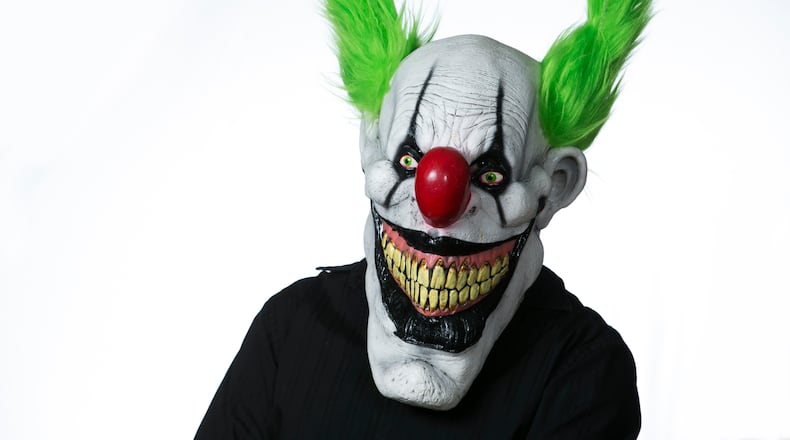 Jason Munger models a Zippo the Clown mask sold at Eddie's Trick & Novelty Shop in Marietta, in anticipation of Halloween. AJC special/Jason Getz